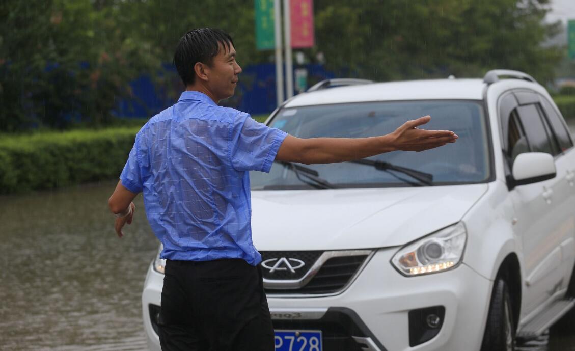 人間菩薩！襯衫男冒著暴雨「把每一輛車都攔下來」　耐心待3個小時拯救上百輛車