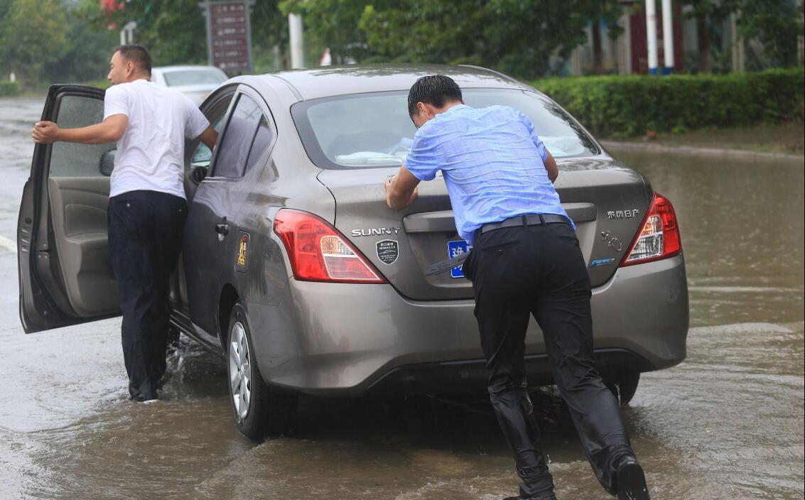 人間菩薩！襯衫男冒著暴雨「把每一輛車都攔下來」　耐心待3個小時拯救上百輛車