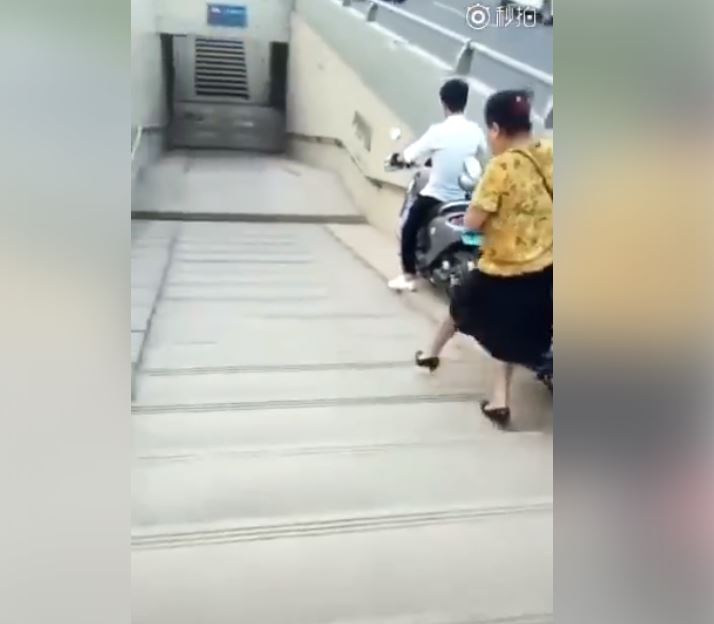 做人別太心急！「阿姨想學小夥子」牽車走地下道　結果下秒「連人帶車…」超悲劇