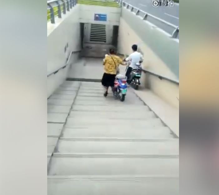 做人別太心急！「阿姨想學小夥子」牽車走地下道　結果下秒「連人帶車…」超悲劇