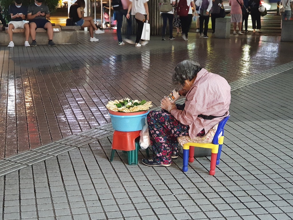 下雨照樣擺攤！玉蘭花阿婆「累到打瞌睡」捲身縮在板凳上　社會局調查回應：「沒有經濟上的困難」