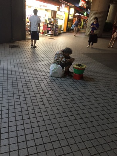 下雨照樣擺攤！玉蘭花阿婆「累到打瞌睡」捲身縮在板凳上　社會局調查回應：「沒有經濟上的困難」