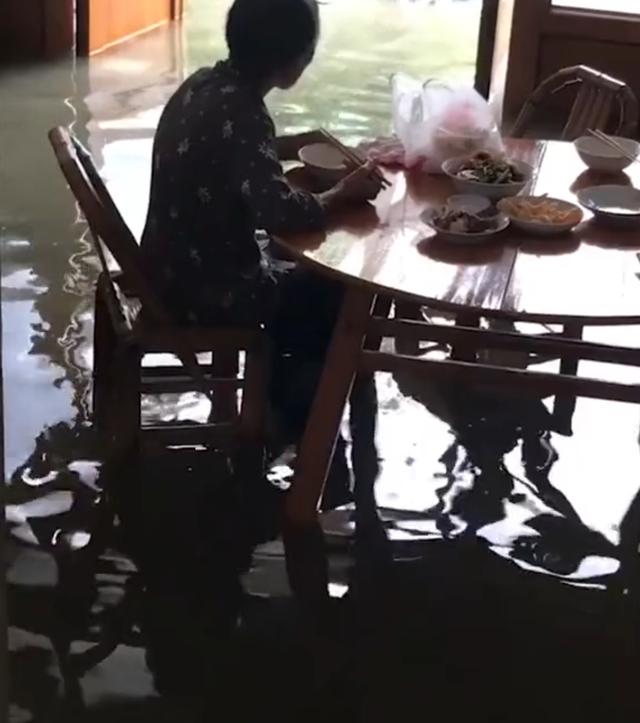 洪水淹沒腿部，老人淡定吃飯：兒啊，等我吃完再背我出去