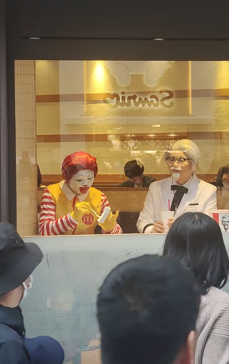 世紀合體!萬聖節街上「麥當勞叔叔+肯德基爺爺」同框現身 手上小牌子「讓路人都笑翻」