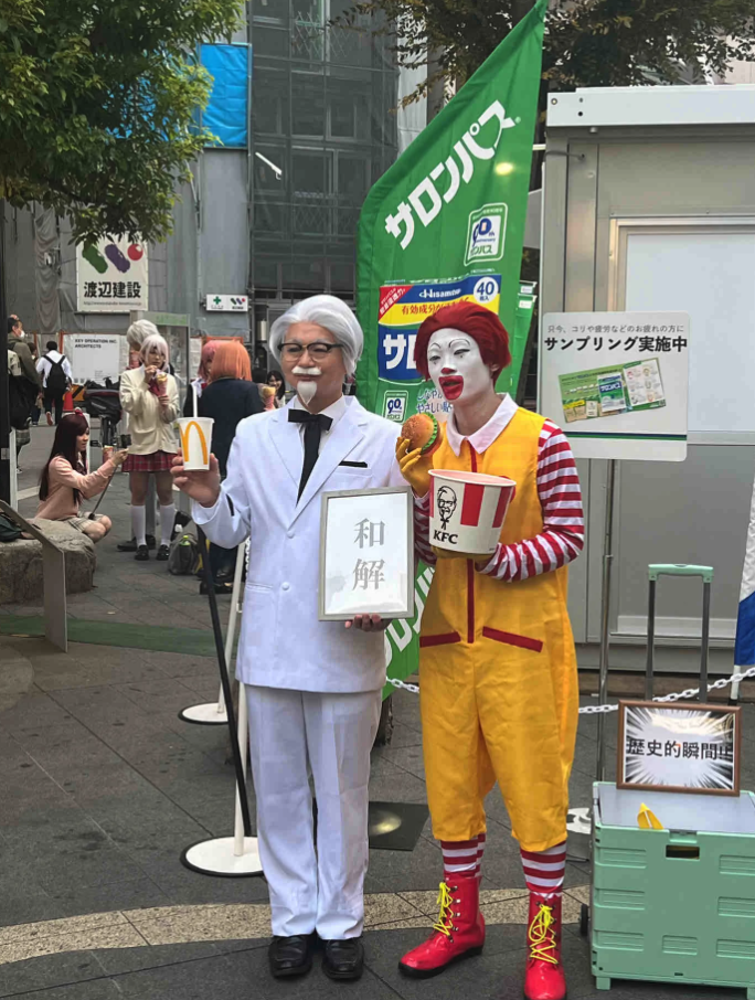 世紀合體!萬聖節街上「麥當勞叔叔+肯德基爺爺」同框現身 手上小牌子「讓路人都笑翻」