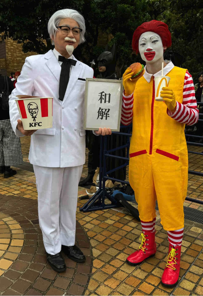 世紀合體!萬聖節街上「麥當勞叔叔+肯德基爺爺」同框現身 手上小牌子「讓路人都笑翻」